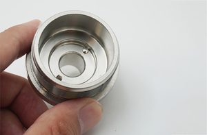 Hand holding a machined stainless steel hub
