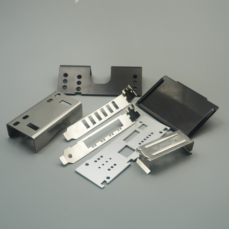 Precision stamped and bent components in black and brushed silver finishes, including U-brackets and slotted panels